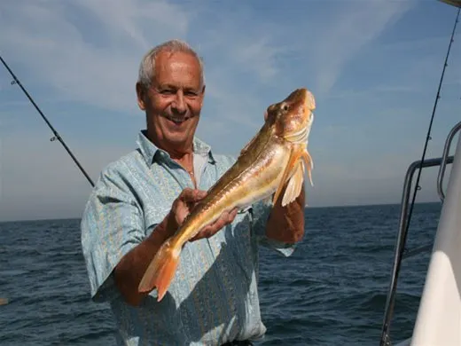 Lachende visser met een poon op zee