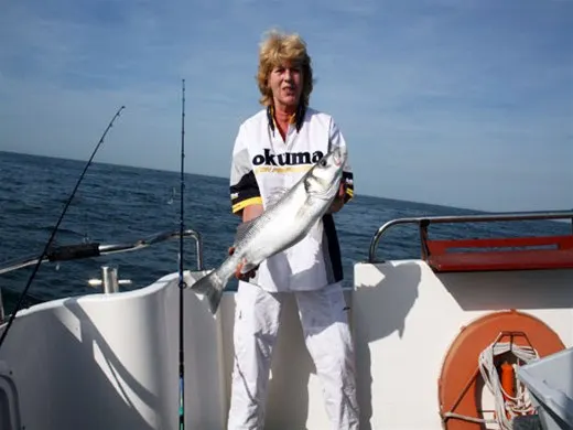 Visster met een zeebaars op de boot