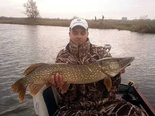 Visser met een snoek in de boot
